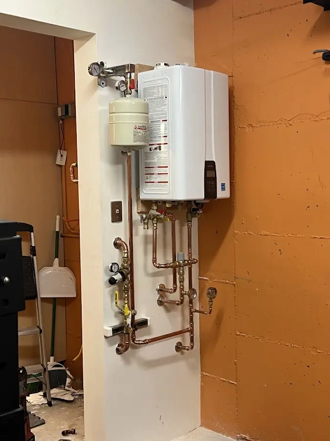 Plumbing technician inspecting water heater connections in Minneola